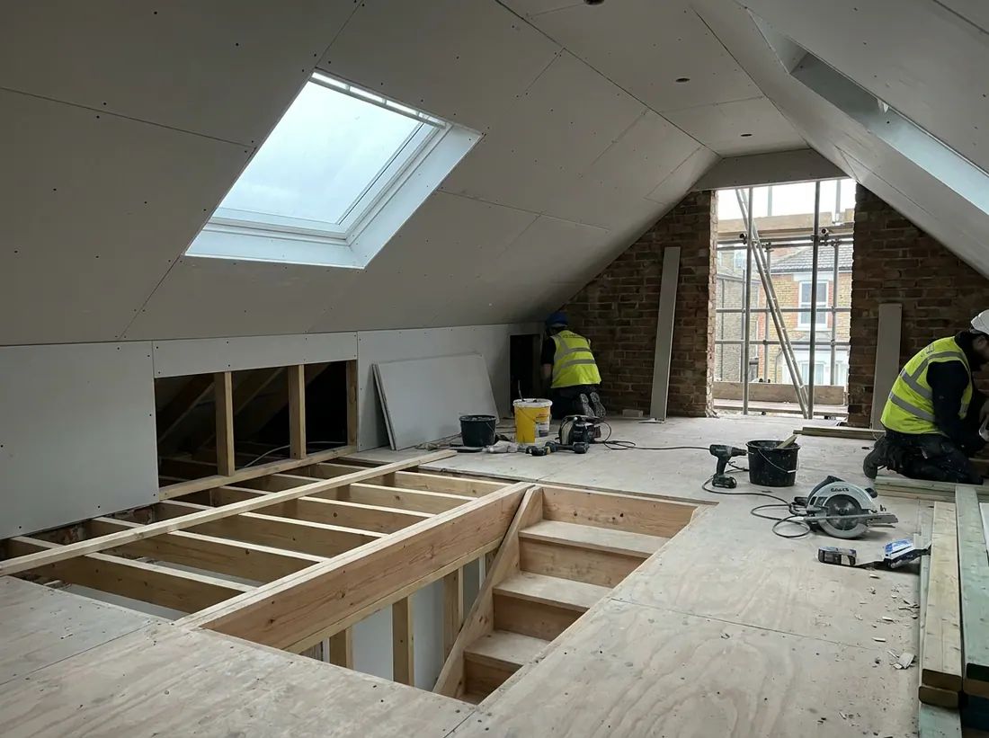 A finished loft conversion bedroom with a roof window