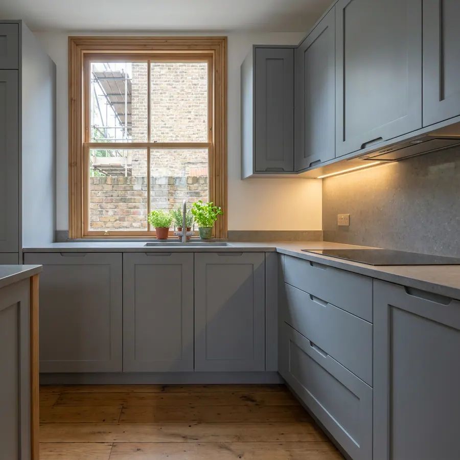 A finished fitted kitchen with a stone worktop
